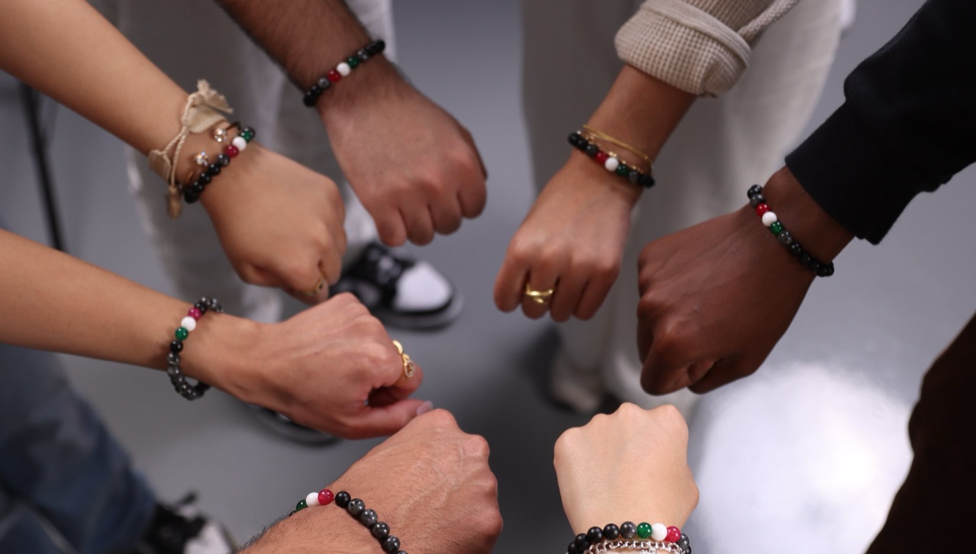 Hands from many backgrounds wearing SoulTies bracelets